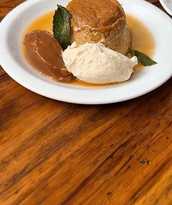 Postre de la casa con dulce de leche y crema en Sandoval, Caballito