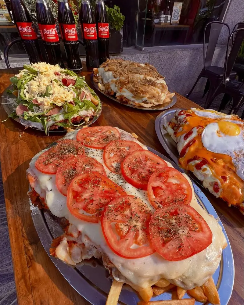 Mesa para compartir con megamilanesa y ensaladas en Sandoval, Caballito